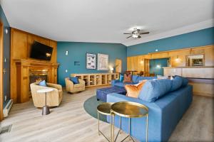 a living room with two blue couches and a fireplace at 6BR Houghton Lake House with Indoor Pool, Hot Tub and Golf Simulator in Prudenville