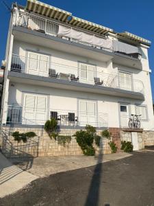 - un bâtiment blanc avec des portes et des fenêtres blanches dans l'établissement Apartman Zlatica, à Dramalj