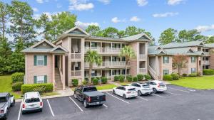 une grande maison avec des voitures garées dans un parking dans l'établissement Beautiful and modern 3 BR Condo in True Blue!, à Pawleys Island