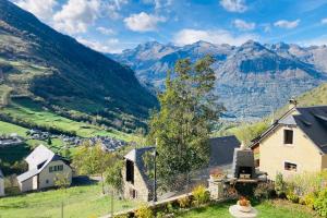 a house on a hill with mountains in the background at Luz St Sauveur, Appartement 3 personnes, superbe vue montagne, exposé sud, Résidence très calme in Luz-Saint-Sauveur