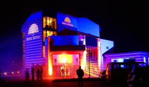 a building with people standing in front of it at night at Hotel Novum & Spa in Niepołomice