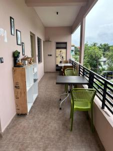 a balcony with a table and chairs on it at Lee home stay in Hampi