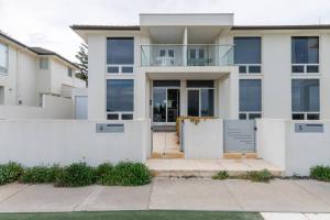 una casa blanca con una puerta y una valla en Sunset Sands on Esplanade By Host Solutions, en West Beach