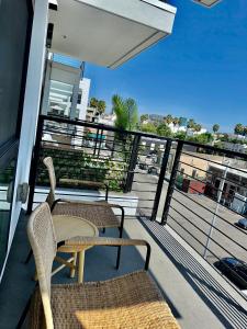 ロサンゼルスにあるCozy apartment in Hollywoodの建物の上に椅子2脚とテーブルが置かれたバルコニー
