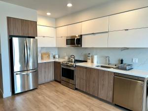 ロサンゼルスにあるCozy apartment in Hollywoodのキッチン(木製キャビネット、ステンレス製の電化製品付)