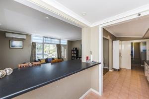 a kitchen and living room with a black counter top at Blueshack - Walking Distance To Foreshore in Guilderton