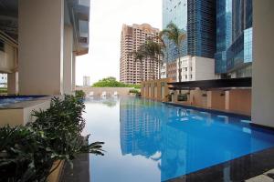 a large swimming pool in a building with tall buildings at The Exchange Regency Residence Hotel Managed by HII in Manila