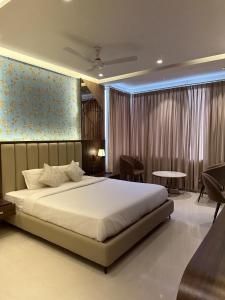 a bedroom with a large bed and a table at Hotel Relax Inn in Bānswāra +22 photos