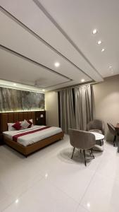 a bedroom with a bed and a desk and a chair at Hotel Relax Inn in Bānswāra