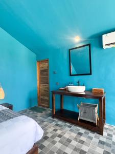 a bathroom with a sink and a blue wall at Aloka Penida in Klungkung