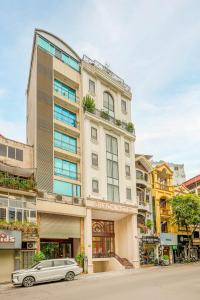 a white car parked in front of a building at Gilson Hanoi Hotel in Hanoi
