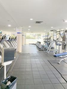 a gym with rows of treadmills and machines at Cozy 2Beds APT with Pool Access in Waterloo in Sydney