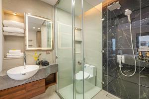 a bathroom with a sink and a glass shower at Gilson Hanoi Hotel in Hanoi +37 photos