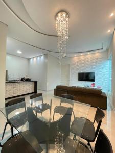 een woonkamer met een glazen tafel en stoelen bij Casa Linda, moderna e aconchegante in Rio Branco