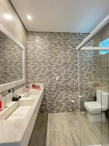 een badkamer met 2 wastafels, een toilet en een douche bij Casa Linda, moderna e aconchegante in Rio Branco +4 foto's