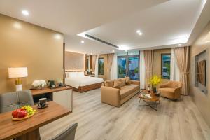 a hotel room with a bed and a living room at Gilson Hanoi Hotel in Hanoi