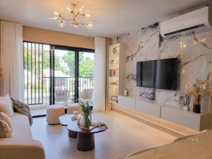 a living room with a tv on a stone wall at Luxury Apartment Downtown in Santiago de los Caballeros