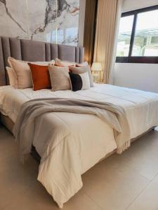 a bedroom with a large bed with many pillows at Luxury Apartment Downtown in Santiago de los Caballeros +39 photos