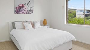 a white bedroom with a white bed and a window at Sea For Days - Panoramic Bay Views in Rye in Rye