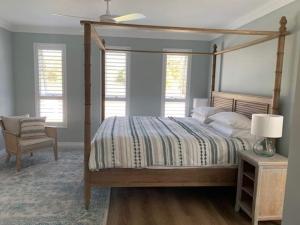 a bedroom with a canopy bed and a chair at Just Beachy By Swan Bnb Management in Carey Park