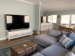 a living room with a couch and a flat screen tv at Just Beachy Swan BnB Management in Carey Park