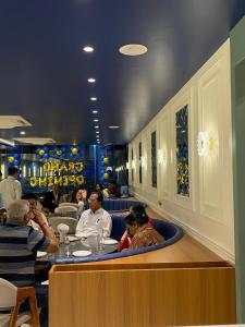 a group of people sitting at a bar in a restaurant at Hotel Relax Inn in Bānswāra