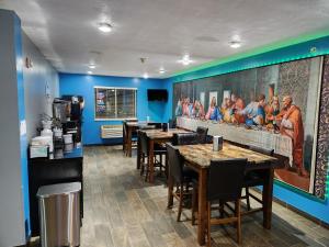 ein Restaurant mit Tischen und Stühlen und einem Gemälde an der Wand in der Unterkunft Super Star Inn & Suite Lincoln Crete in Crete