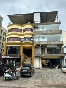 a building with cars parked in front of it at Hotel Relax Inn in Bānswāra