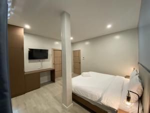 a bedroom with a bed and a flat screen tv at The European Chiang Mai in Chiang Mai
