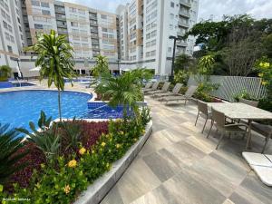 Un patio con mesas y sillas y una piscina. en Rio Quente Park Veredas Flat - Proximo ao Hot Park - Acesso ao rio - A1, en Rio Quente 159 fotos más