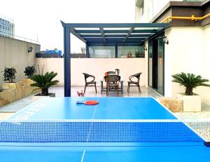 una mesa de ping pong azul en el patio en Tao's Inn Guiyang, en Longli