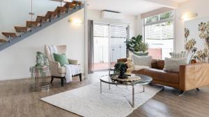 una sala de estar con un sofá y una mesa en The Lookout Lounge - Pet Friendly, Pool, Great Views!, en Coffs Harbour