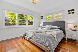 a white bedroom with a bed and windows at Beach Holiday Home-Close to Airport-3 Bed & 2 Bath in Lauderdale