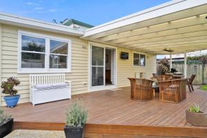 a wooden deck with chairs and a table at Beach Holiday Home-Close to Airport-3 Bed & 2 Bath in Lauderdale