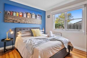 a bedroom with a bed with blue walls and a window at Beach Holiday Home-Close to Airport-3 Bed & 2 Bath in Lauderdale