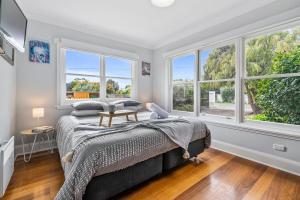a bedroom with a bed and two windows at Beach Holiday Home-Close to Airport-3 Bed & 2 Bath in Lauderdale