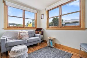 a living room with a couch and two windows at Beach Holiday Home-Close to Airport-3 Bed & 2 Bath in Lauderdale