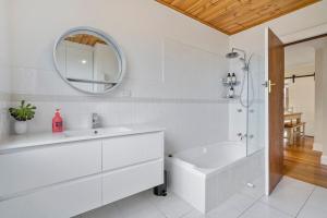 a bathroom with a tub and a sink and a mirror at Beach Holiday Home-Close to Airport-3 Bed & 2 Bath in Lauderdale