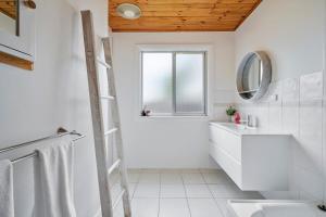 a bathroom with a ladder next to a sink and a mirror at Beach Holiday Home-Close to Airport-3 Bed & 2 Bath in Lauderdale