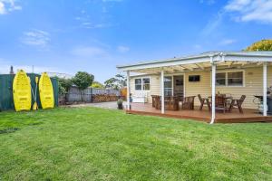 a yellow house with a deck and a yard at Beach Holiday Home-Close to Airport-3 Bed & 2 Bath in Lauderdale