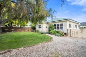 a small white house with a fence and a yard at Beach Holiday Home-Close to Airport-3 Bed & 2 Bath in Lauderdale