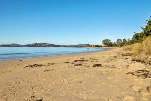 a sandy beach with trees and the water at Beach Holiday Home-Close to Airport-3 Bed & 2 Bath in Lauderdale