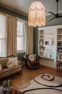 a living room with a couch and a chandelier at La Cochon Rose Motel in Saint Arnaud