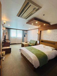 Una habitación de hotel con una cama grande y un sofá. en Hotel Good Morning, en Ulsan 24 fotos más