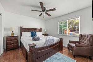 une chambre avec un lit avec un ventilateur de plafond et une chaise dans l'établissement Coastal Home Near UCSB & Airport, Hot Tub, King Beds, Fast Wifi, Sleeps 6, à Santa Barbara