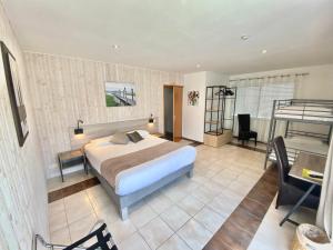 a large bedroom with a bed and a desk and a desk at Logis Hôtel L'Oliveraie in Cognac
