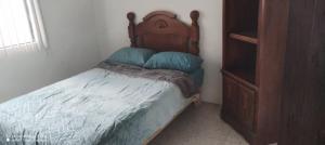 a small bed with a wooden headboard in a bedroom at Esmeralda in Querétaro +8 photos