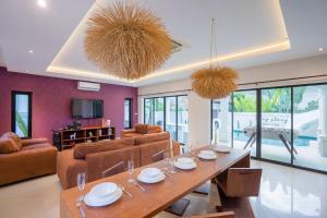ナ・ジョムティエンにあるPlay Story Pool Villa Na Jomtienのテーブルとソファのあるリビングルーム