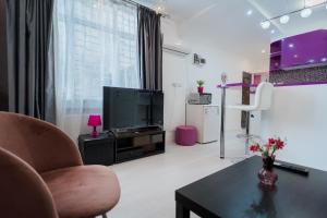 a living room with a tv and a table at Ultra Central White & Lila Studio in Bucharest +5 photos