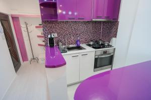 a purple kitchen with a sink and a stove at Ultra Central White & Lila Studio in Bucharest